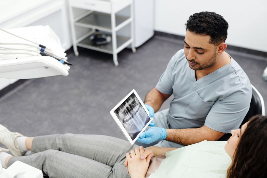 Dentist showing a relaxed patient her panoramic X-ray on a tablet