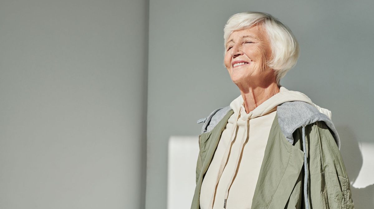 Older woman smiling comfortably in warm daylight