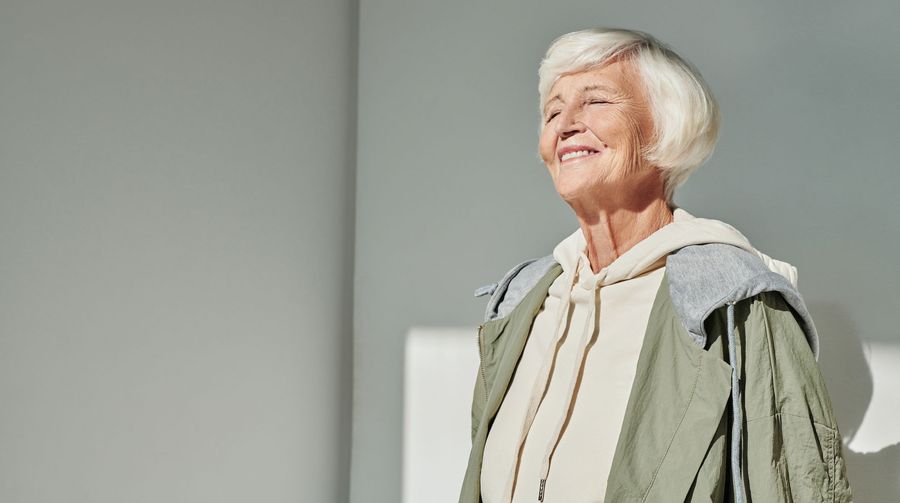 Older woman smiling comfortably in warm daylight