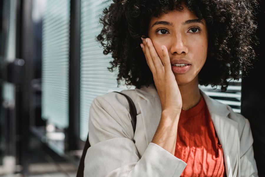Woman resting a hand against her jaw in mild discomfort